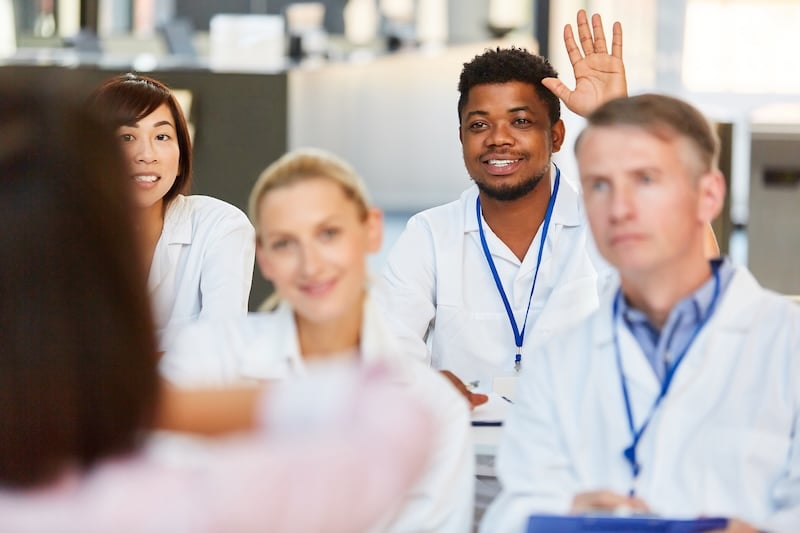 Students in class with a hand raised.